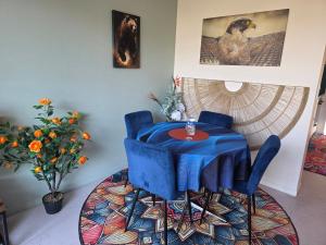 a blue table and chairs in a room at Le Cercle de Victoria stationnement privé petit déjeuner compris in Bourges