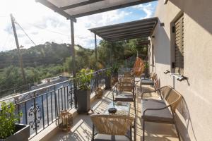 a balcony with chairs and tables and a view at Εlysian III in Mavrovouni