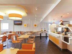 a restaurant with tables and chairs and a bar at Ibis Budget Rambouillet in Rambouillet