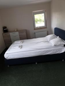 a large bed in a bedroom with a window at Zacišių Sodyba in Karalgiris