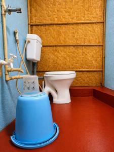 a bathroom with a toilet and a water cooler at Gowri Guest House in Hampi