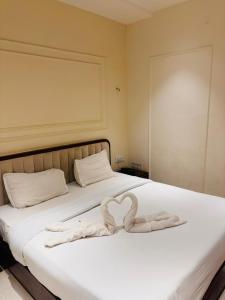 a bed with two towels in the shape of a heart at Hotel Corporate in Shivpurī