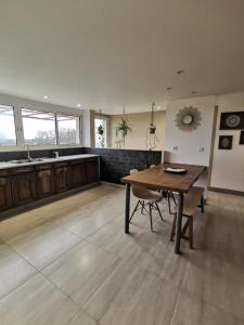 a kitchen with a wooden table and a dining room at Dépendance avec jardin privé et vue sur campagne in Puydaniel