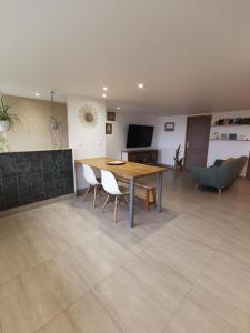 a living room with a wooden table and chairs at Dépendance avec jardin privé et vue sur campagne in Puydaniel