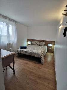 a bedroom with a bed and a wooden floor at Dépendance avec jardin privé et vue sur campagne in Puydaniel