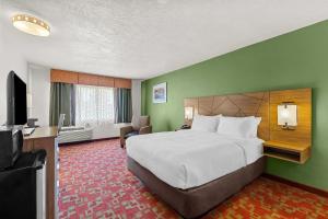 a hotel room with a bed and a flat screen tv at Quality Inn Evanston near Wyoming Downs in Evanston