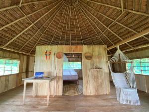 a tent with a hammock and a laptop on a table at Hostal Maguare-Reserva Indígena Maguare in Leticia