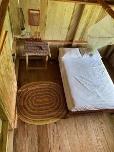 an attic bedroom with a bed and a table at Hostal Maguare-Reserva Indígena Maguare in Leticia