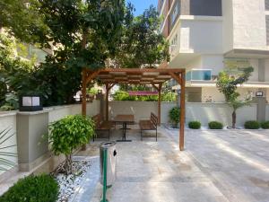 a wooden pergola with chairs and tables in a courtyard at Rubin residence in Alanya