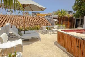 a patio with chairs and an umbrella and a pool at Hotel Bantu by Faranda Boutique, a member of Radisson Individuals in Cartagena de Indias +88 photos