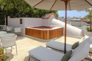 a patio with tables and chairs and an umbrella at Hotel Bantu by Faranda Boutique, a member of Radisson Individuals in Cartagena de Indias