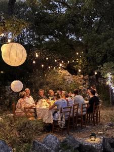 a group of people sitting at a dinner table at night at L'évidence en Provence in Vachères