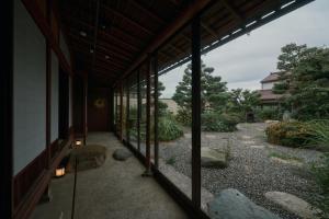 a screened in porch with a view of a garden at 安宅ノ宿 沖 in Komatsu