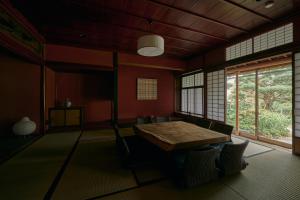 a room with a table and chairs and windows at 安宅ノ宿 沖 in Komatsu