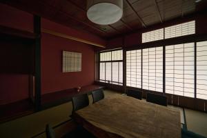 a room with a wooden table and chairs and windows at 安宅ノ宿 沖 in Komatsu
