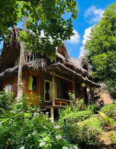an old house with a thatched roof at Đà Lạt Củi Homestay in Da Lat
