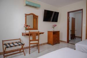 a bedroom with a desk and a mirror and a bed at Hotel Faranda Bolivar Cucuta, a member of Radisson Individuals in Cúcuta