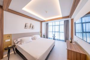 a bedroom with a large bed and a large window at Hotel Faranda Rias Altas, Ascend Hotel Collection in Oleiros
