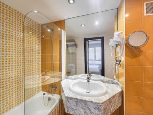 a bathroom with a sink and a shower and a tub at Hotel Faranda Pathos Gijón, Ascend Hotel Collection in Gijón