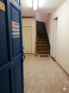 a hallway with a staircase and a blue door at La Plage in Fécamp