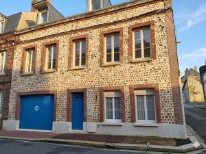 a brick building with blue doors and windows at La Plage in Fécamp