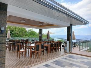 a restaurant with tables and chairs on a balcony at Highlights Taal Lake View Resort in Santol