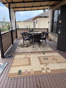 a patio with a table and chairs on a deck at Diamond Resort Cottage Issyk-Kul in Bosteri