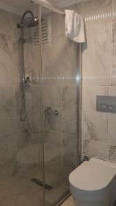a bathroom with a glass shower with a toilet at Kemer Otel in Bartın