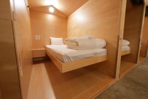 a small room with a bed and a mirror at 女性専用 Woman Only capsule MAJA HOTEL KYOTO マヤホテルキョウト in Kyoto +35 photos