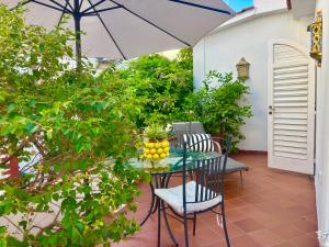 a patio with a table and chairs and an umbrella at Syrene Suites Sorrento in Piano di Sorrento