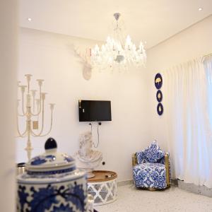 a dining room with a chandelier and a chair at Greece In Blue in Kandivalli