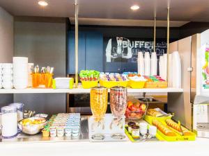 a kitchen with a counter with fruits and vegetables at Ibis Budget Marmande in Marmande