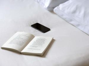 a book sitting on a bed with a black box at Ibis Budget Marmande in Marmande +41 photos