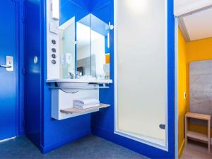 a bathroom with a sink and a mirror at Ibis Budget Marmande in Marmande