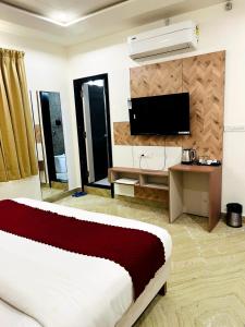 a living room with a bed and a television at Hotel Anand Inn in Kota