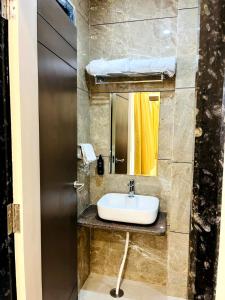 a bathroom with a sink and a bed at Hotel Anand Inn in Kota