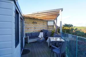 a patio with a table and chairs on a deck at Studio room with amazing views in Abersoch +11 photos