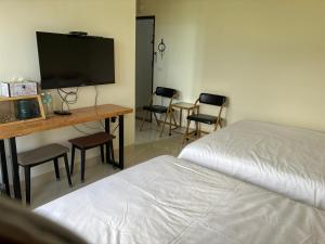 a bedroom with a bed and a desk with chairs at Green Home in Yuli