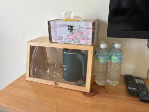 a wooden shelf with a box and two bottles of water at Green Home in Yuli +28 photos
