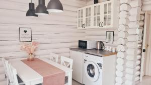 a laundry room with a table and a washing machine at Csendliget Villas Abádszalók in Abádszalók