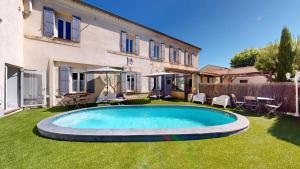 a swimming pool in the yard of a house at L'Escale des Alpilles in Rognonas