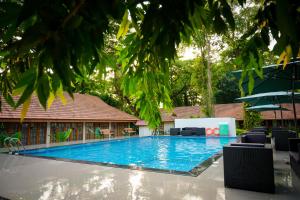 a large blue swimming pool in front of a building at KTDC Kumarakom Gateway Resort in Alleppey +26 photos