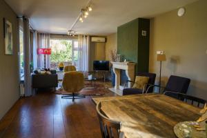 a living room with a table and chairs and a couch at 't Achterhuis (8 persons) in Otterlo