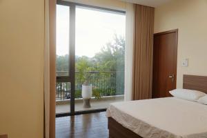 a bedroom with a bed and a large glass window at Reka Homestay in Thôn Dương Phẩm