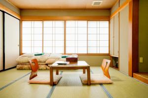 a living room with a table and chairs and a couch at Shibuonsen YAMAICHIYA in Yamanouchi