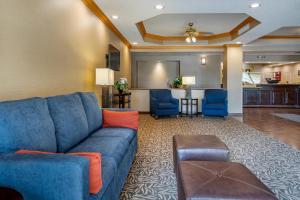 a living room with a blue couch and a kitchen at Comfort Inn Charlotte in Charlotte