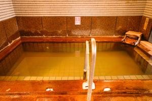 a large pool of water in a bathroom with at Shibuonsen YAMAICHIYA in Yamanouchi +2 photos