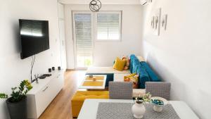 a living room with a blue couch and a tv at Apartment Antonia - Gevgelija in Gevgelija