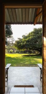 an open door to a patio with two benches at Kruger Foothills Lodge - Near Kruger National Park in Hoedspruit