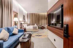 a living room with a blue couch and a tv at فندق كورنيت النورس - جدة in Jeddah